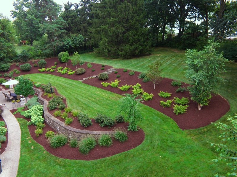 Terraced South Hills landscape retreat with curved retaining wall, mulched beds, and paver patio
