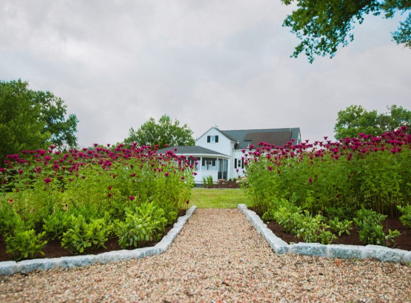 Planting beds with stone-lined gravel pathway leading to a South Hills home