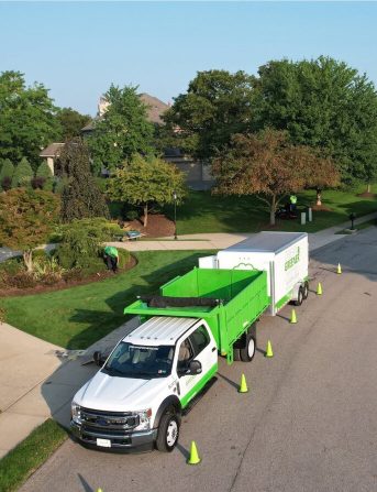 Dream Greener truck and trailer parked with safety cones while the crew works on a client property