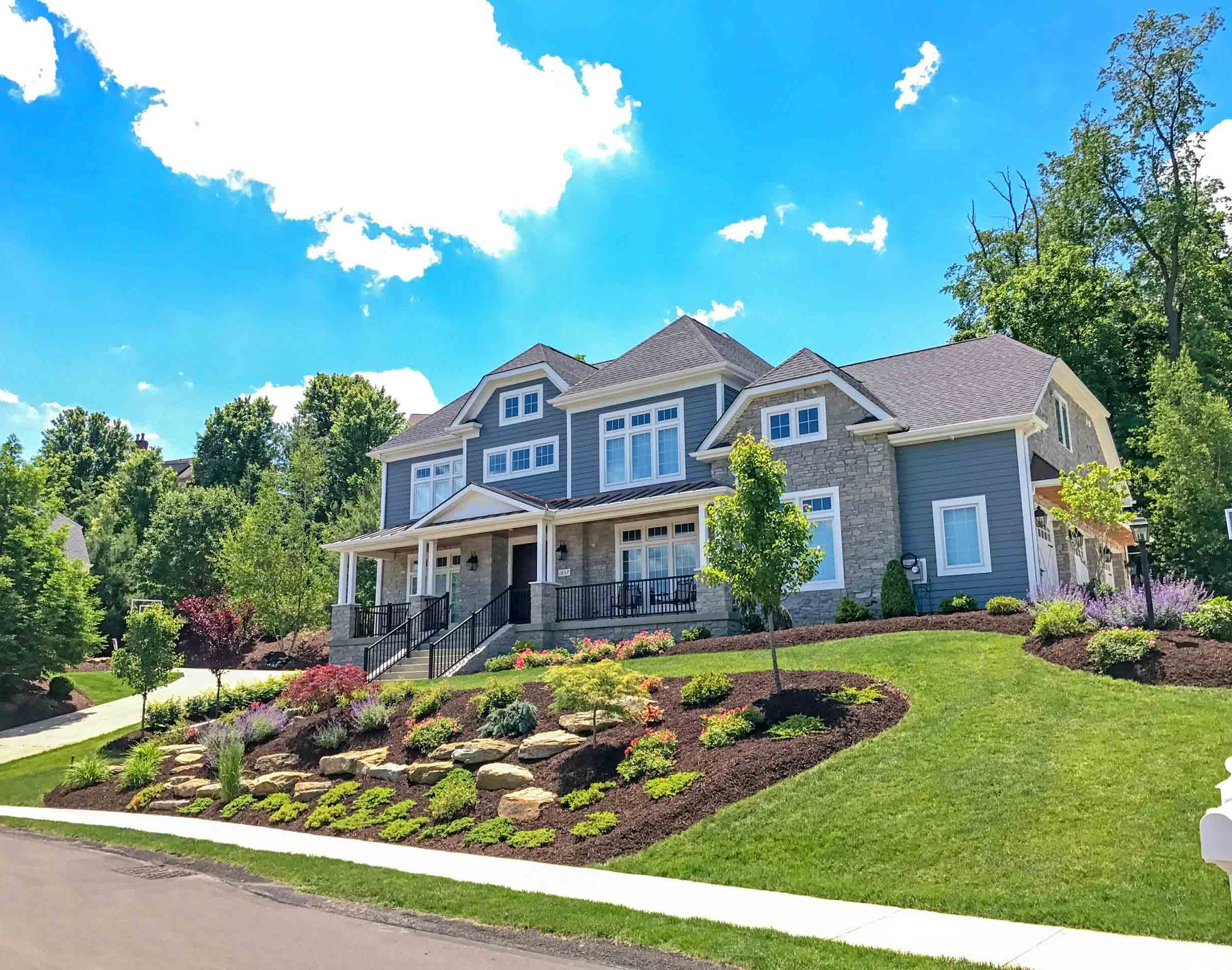 Front yard landscape installation with boulder beds and new plantings