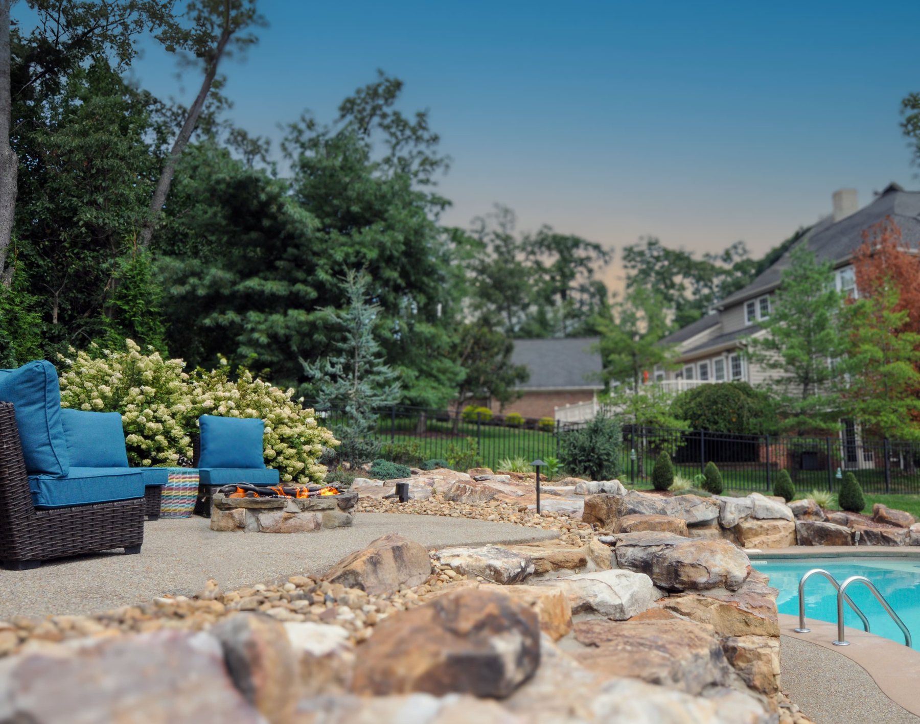 Patio seating area beside a boulder-edged pool
